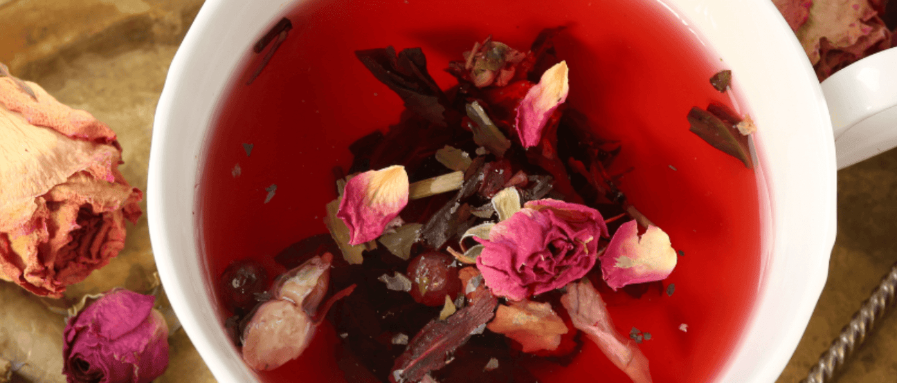 Herbal adaptogenic tea blend in a cup with flowers.