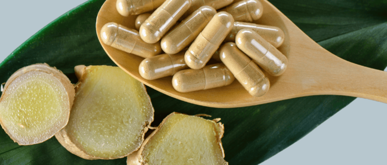 Ginger capsules and fresh root on a leaf, representing ginger supplements for inflammation relief.