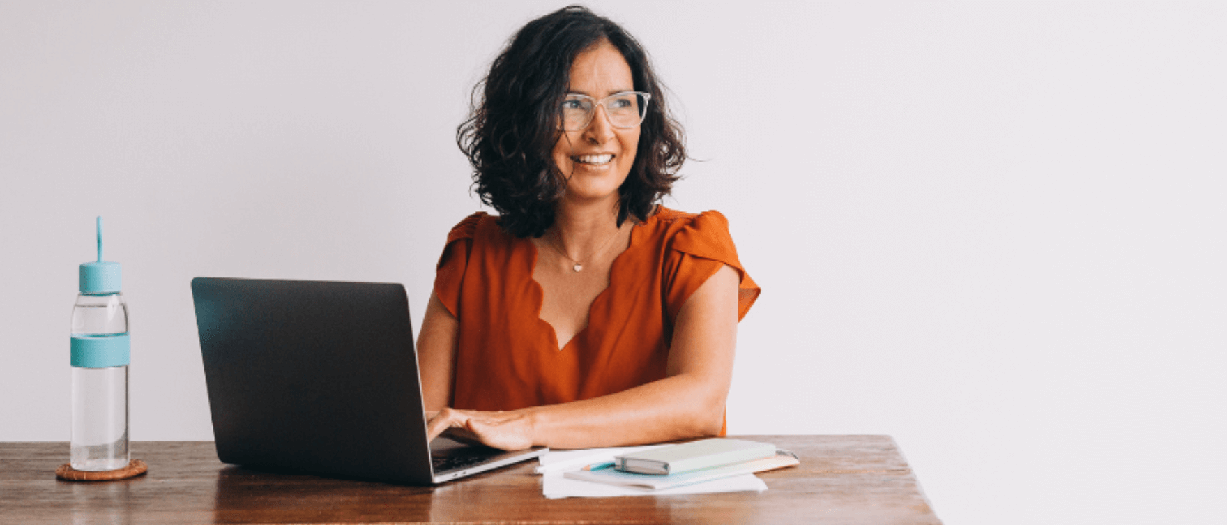 A digital banner showing a woman working at her laptop, symbolizing consistency and productivity in building healthy habits.