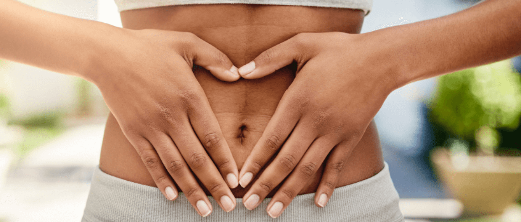 Healthy woman holding her stomach, representing a balanced microbiota.