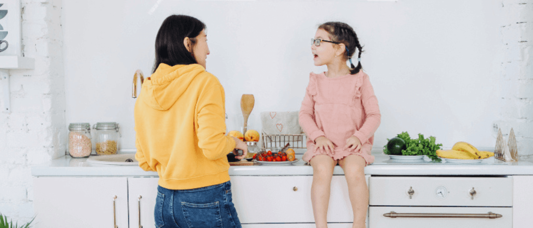 A mother and daughter preparing healthy meals together in a bright kitchen.