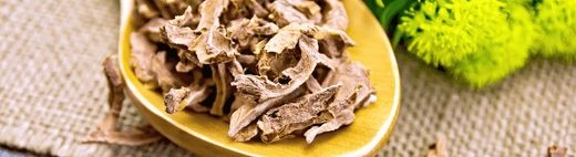 Close-up of dried Rhodiola rosea roots with fresh green herbs, emphasizing its resilience and vitality.