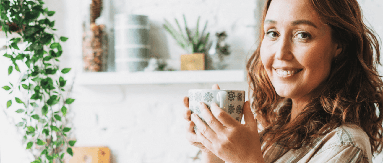 A happy woman practicing self-care and relaxation with natural wellness strategies.