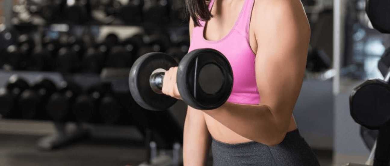 A woman performing strength training exercises, emphasizing the role of turmeric in reducing inflammation and enhancing recovery.