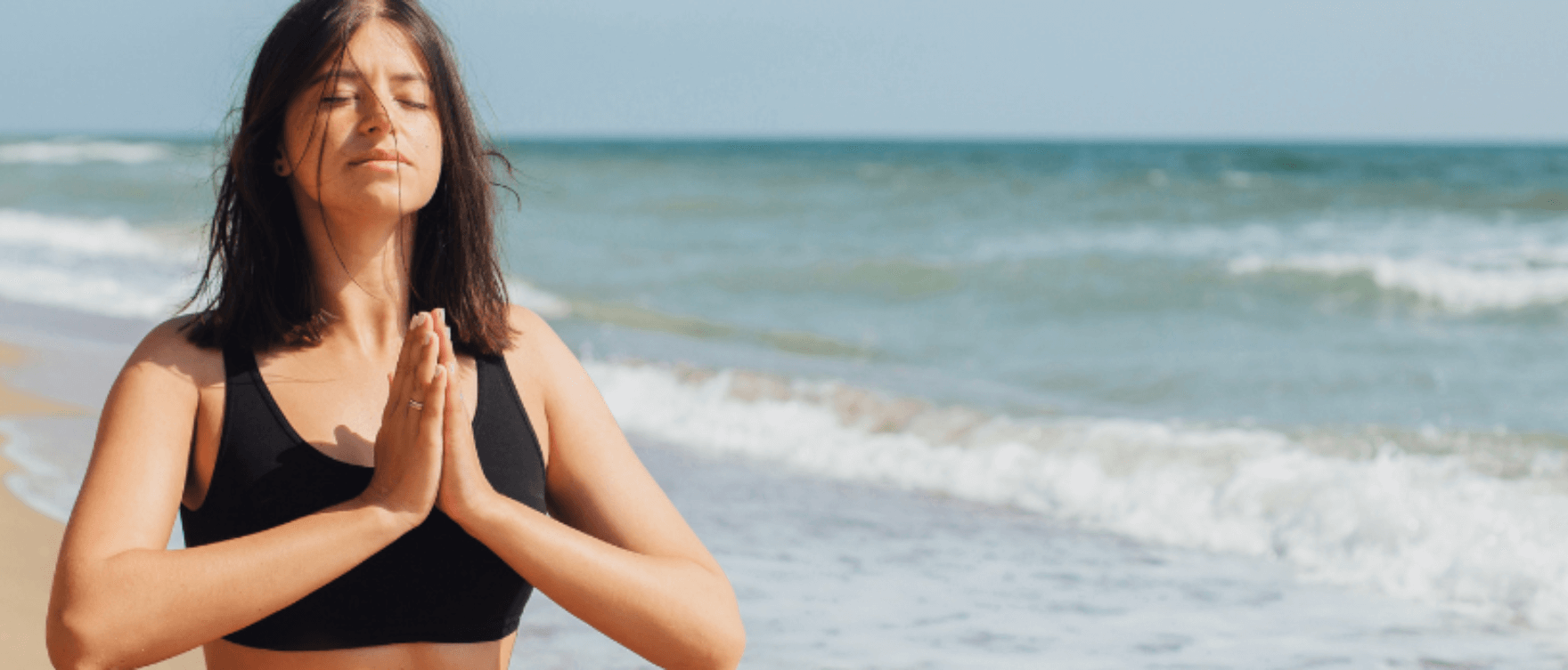 Woman meditating peacefully by the ocean, symbolizing mental balance and inner peace through Ayurveda.