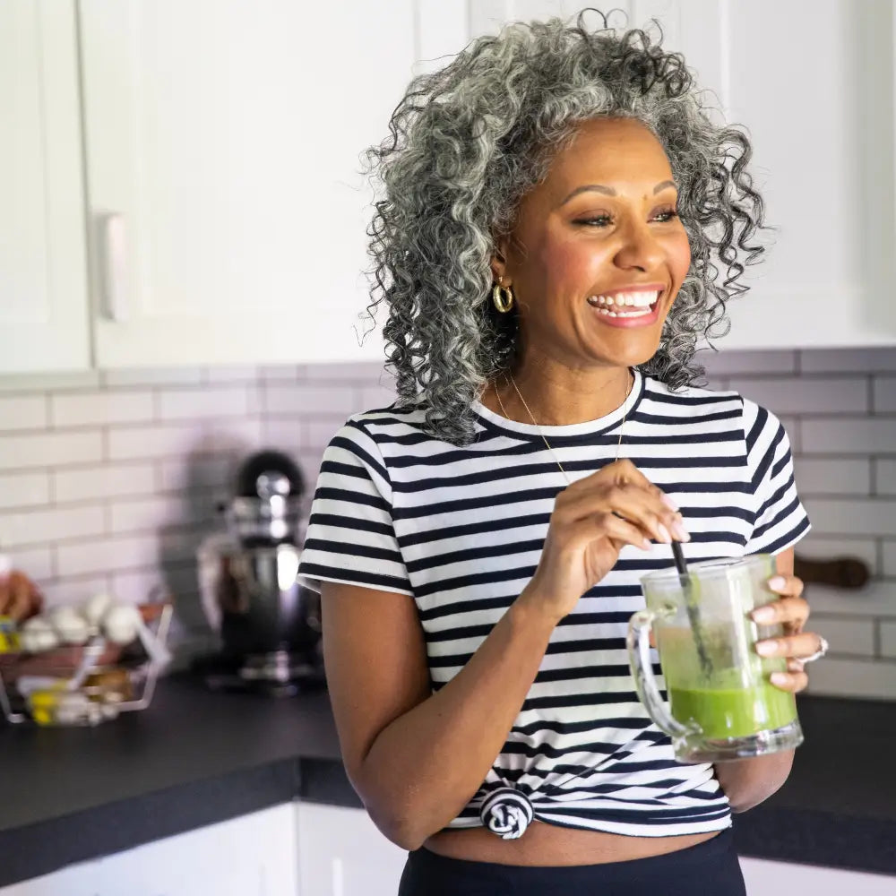 Woman drinking a smoothie in the kitchen