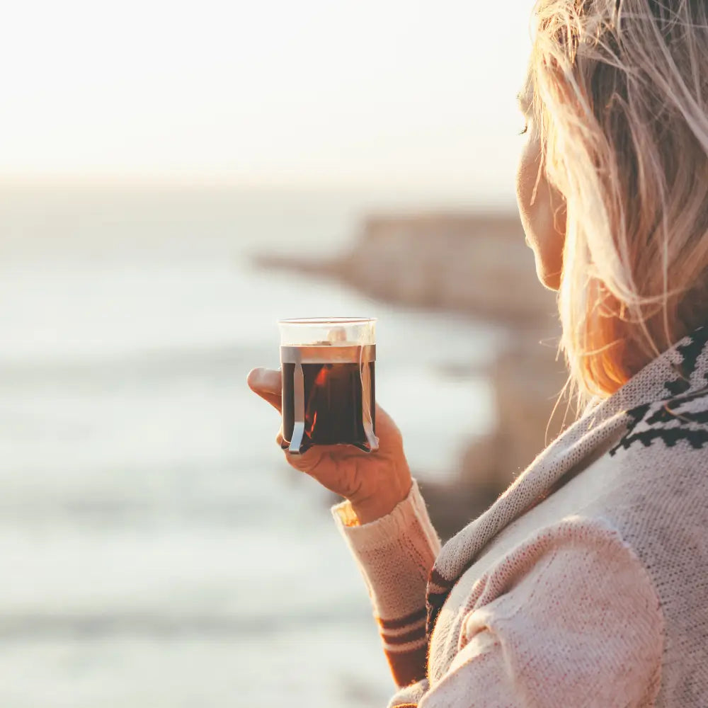 Woman drinking tea at the beach